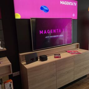 Modernes MagentaTV-Display mit TV-Gerät und Streaming-Box im Telekom-Shop präsentiert.